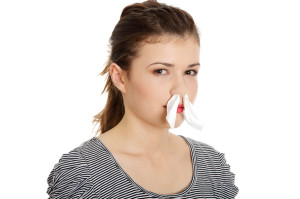 Teen woman with tissue in her nose